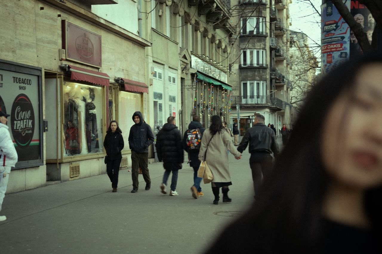 A busy street with a blurred face close to the lens
