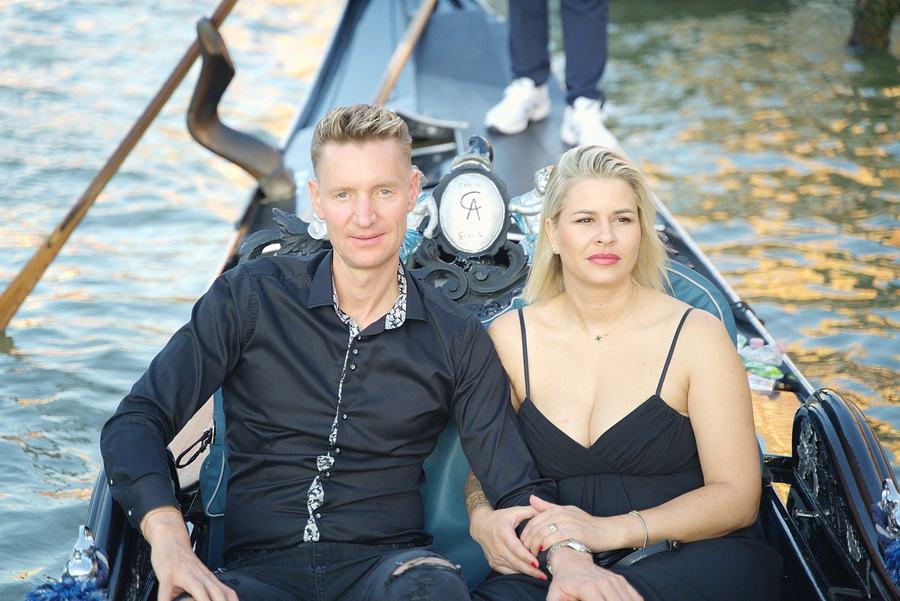 A couple dressed in black sitting close together on a gondola