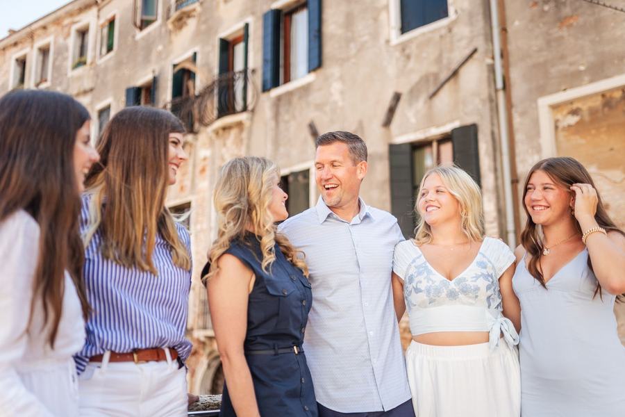 A family laughing together in front of an old Venetian facade
