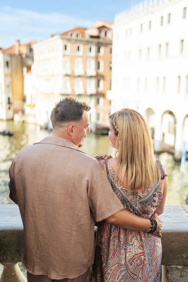A couple seen from behind, talking above the Grand Canal